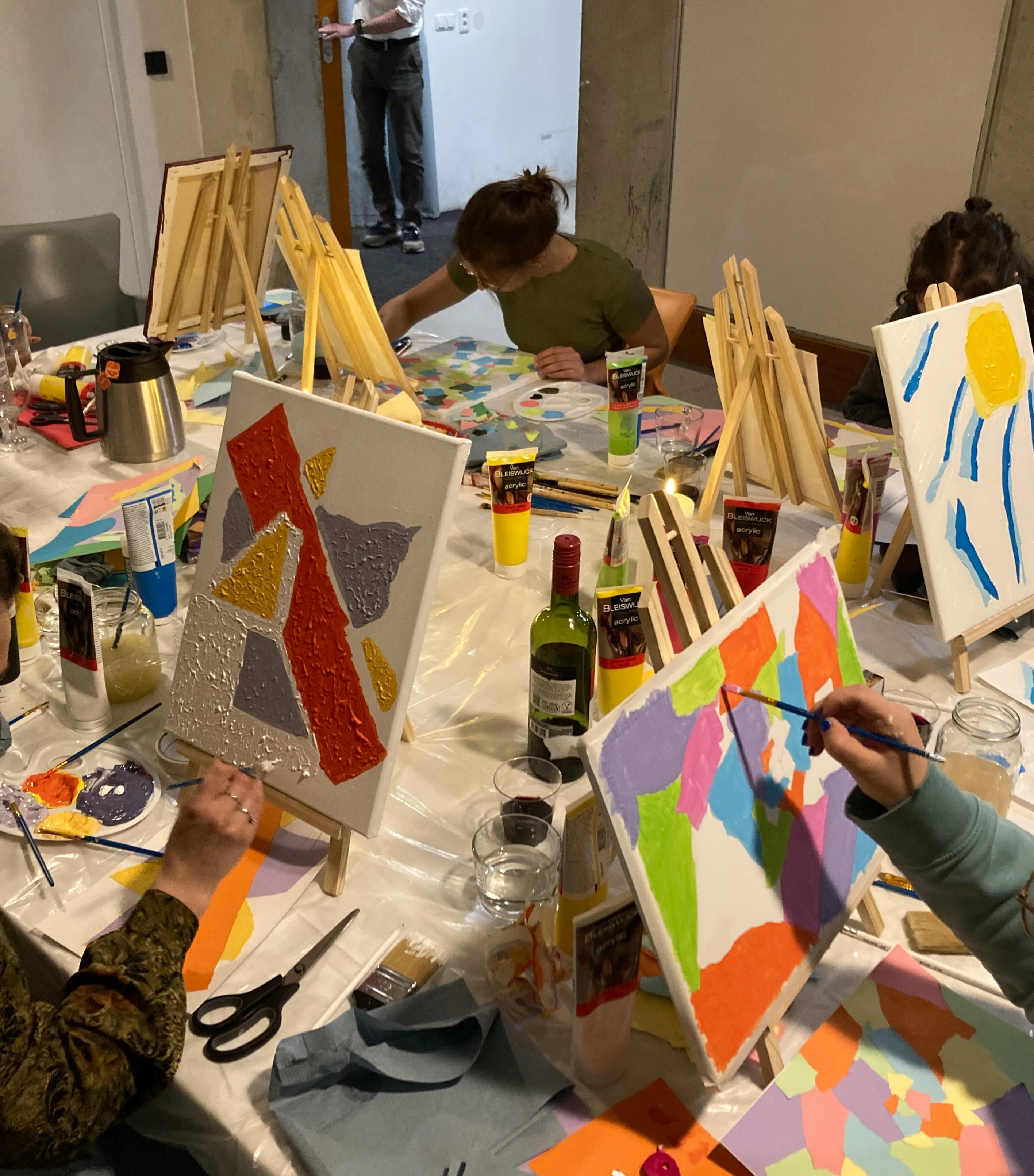 Deelnemers werken aan hun schilderij tijdens een workshop
